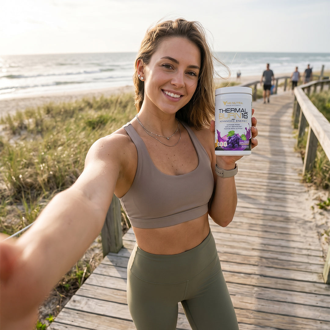 Fit woman holding NG Nutra's Thermalburn16 on a beach boardwalk.